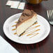 A slice of cheesecake on a Carlisle Sierrus white melamine pie plate.