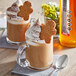Two glasses of coffee with whipped cream and gingerbread man on top next to SHOTT Gingerbread Flavoring Syrup.
