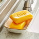 Two yellow Dial Gold antibacterial bar soaps in a dish.