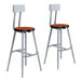 A pair of National Public Seating Titan lab stools with a cherry seat and backrest.
