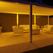 A white patio with a covered area and a table and chairs set up with an Ape Labs Stick XL 2.0 LED light on it.
