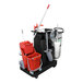 A black Unger RestroomRX cleaning cart with a red Unger RestroomRX bucket and handle and two white Unger RestroomRX mop buckets on it.
