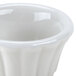 A close-up of a white flared ramekin with a lid.