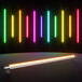 A group of Ape Labs Stick 2.0 LED lights with colorful neon lights on a black surface.