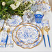 A table setting with blue and white Sophistiplate cocktail napkins, tableware, and flowers.