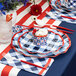 Sophistiplate red and white plastic cutlery on a table with blue and white checkered plates and napkins.