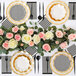 A table setting with Sophistiplate Blanc & Noir paper cocktail napkins, black and white plates, and flowers.