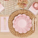 A table setting with Sophistiplate blush pink scalloped edge paper napkins and pink plates.