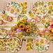 A Sophistiplate sunflower paper salad plate on a table set with sunflowers.