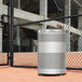 A Rubbermaid stainless steel perforated waste receptacle.