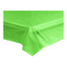 A lime green plastic tablecloth unrolled over a white surface.