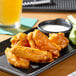 A plate of Sweet Baby Ray's buffalo chicken wings with celery and dip.