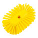 A yellow circular Carlisle brush with a hole in it.