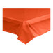 A Choice tangerine plastic tablecloth on a table.