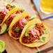 A group of tacos with Abbot's Butcher Plant-Based Vegan Chorizo crumbles on a wooden board.
