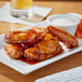 A plate of Sweet Baby Ray's Korean Barbecue chicken wings with dip.