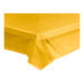 A Choice yellow plastic tablecloth roll on a white table.