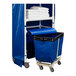 A blue Royal Basket Trucks laundry cart with a blue bin and white towels.