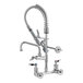 A chrome T&S Mini-PRU wall-mounted pre-rinse faucet with a silver hose and sprayer.