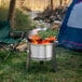 A BREEO stainless steel fire pit in front of a tent.