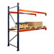 A blue and orange Interlake Mecalux heavy-duty bolted pallet rack with boxes on it.