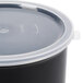 A black Carlisle round polypropylene crock lid on a clear container.