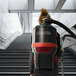 A woman walking down stairs with a NaceCare corded backpack vacuum.