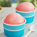 Two cups of Philadelphia Water Ice cotton candy Italian ice with spoons on a table.
