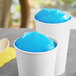 Two cups of blue Philadelphia Water Ice on a table.