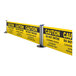 A ZonePro customizable dual rolling stanchion with a yellow caution sign and black and yellow caution tape.