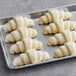 A metal tray of unbaked Gourmand Vegan Straight Croissants.