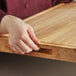 A person holding a Choice wood cutting board.