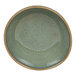 A close-up of a moss green Front of the House Artefact ramekin with a brown rim.
