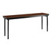 A National Public Seating Montana Walnut plywood folding table with black legs.