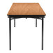 A National Public Seating rectangular Bannister Oak plywood folding table with black legs and T-mold edge.