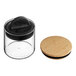 A Planetary Design glass food storage container with a bamboo lid on a wooden surface.