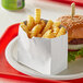 A Bagcraft white foil insulator holding a burger and fries.