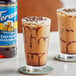 Two glasses of iced coffee with brown liquid and Torani Sugar-Free Chocolate Macadamia Nut syrup.