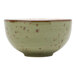 A close-up of a Tuxton olive china soup bowl with brown specks.