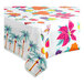 A Table Mate floral luau plastic tablecloth roll with tropical designs on a table.