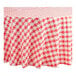 A red and white checkered Table Mate round plastic table cover on a table.
