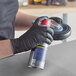 A person wearing black Lavex Pro nitrile gloves holding a spray can.