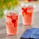 Two Choice clear plastic cups with strawberries and ice.