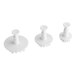 A set of three white plastic Ateco snowflake plunger cutters.