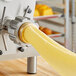 A yellow machine with a piece of dough being made.