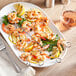 A plate with Choice stainless steel flat skewers holding grilled shrimp and lemon slices.