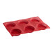 A red silicone bread and pastry mold with 6 round cavities.