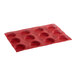 A red silicone baking tray with round micro-perforated cavities.