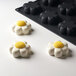 A white and yellow Pavoni silicone baking mold with flower-shaped compartments.