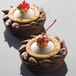 Two desserts in Pavoni Formasil molds with a cherry on top.